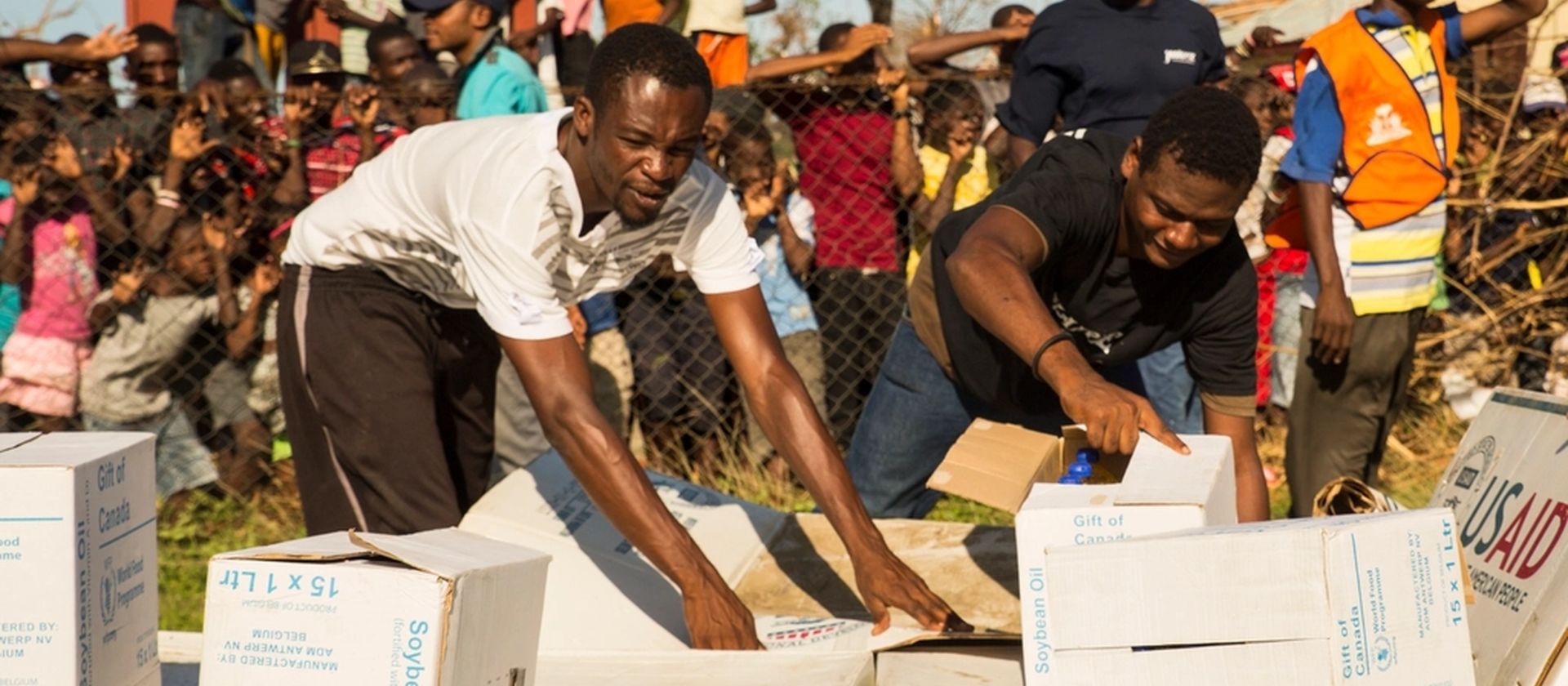 Volunteers unpacking and distributing relief supplies to a waiting community